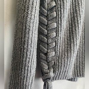 Grey sweater with crossover stitching on the side